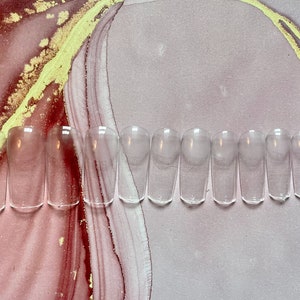 May include: A set of ten clear, plastic, oval-shaped false nails.