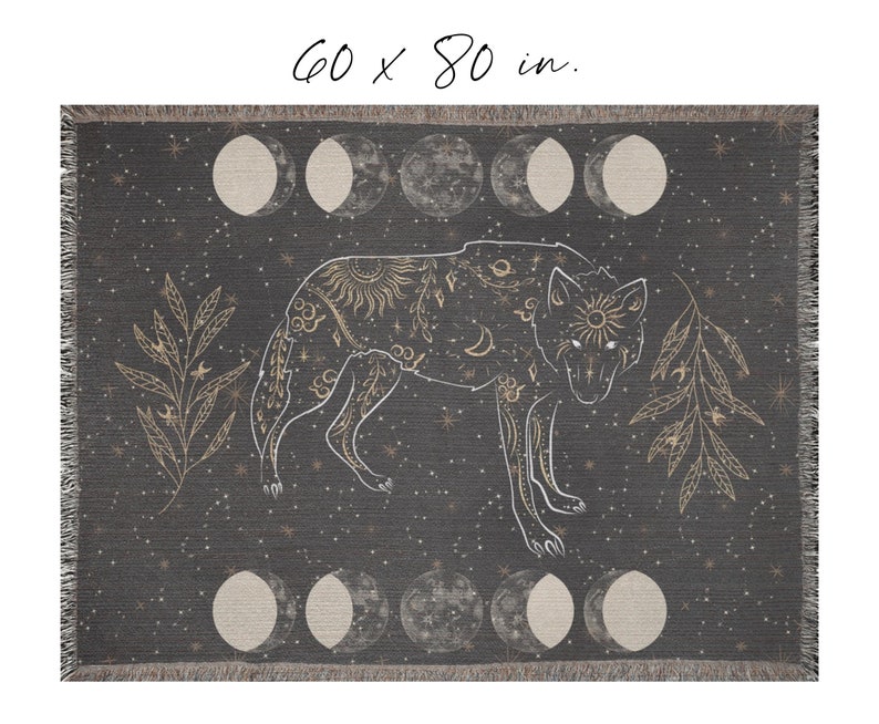 May include: A woven throw blanket with a dark gray background and a white wolf silhouette. The wolf is surrounded by gold stars, moons, and leaves. The blanket measures 60 x 80 inches.