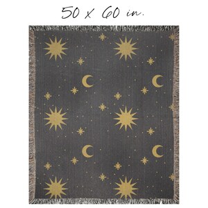 K&ouml;nnte beinhalten: Eine dunkelgraue gewebte Wolldecke mit einem sich wiederholenden Muster aus goldenen Sternen und Mondsicheln. Die Decke misst 127 x 152 cm.
