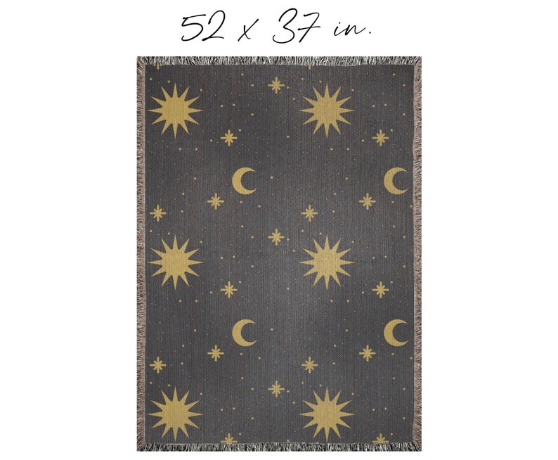 K&ouml;nnte beinhalten: Eine gewebte Wolldecke mit dunkelgrauem Hintergrund und einem Muster aus goldenen Sternen und Mondsicheln. Die Decke misst 132 x 94 cm.