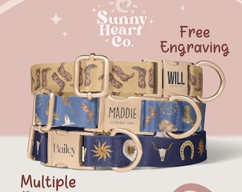 May include: Three personalized dog collars with gold-colored buckles. The top collar is tan with brown cowboy boots, the middle is blue with cowboy-themed designs, and the bottom is navy with a sun and steer skull.