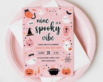 Puede incluir: Una invitación rosa con temática de Halloween con el texto "nine is a spooky vibe". La invitación incluye ilustraciones de calabazas, fantasmas, murciélagos y un gato negro. La invitación está sobre un plato rosa con un sobre blanco.
