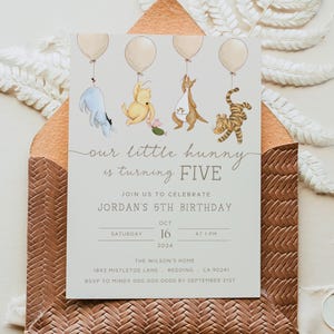 Puede incluir: Una invitación de cumpleaños con temática de Winnie the Pooh con un fondo gris claro. La invitación presenta cinco globos con Winnie the Pooh, Piglet, Tigger, Eeyore y Kanga. El texto dice "Nuestro pequeño hunny está cumpliendo CINCO. Únase a nosotros para celebrar el 5º cumpleaños de Jordan. Sábado, 16 de octubre de 2024 a la 1 PM. La casa de los Wilson, 1893 Mistletoe Lane, Redding, CA 90241. RSVP a Mindy 000.000.0000 antes del 21 de septiembre."