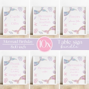 Puede incluir: Un conjunto de seis letreros de mesa con temática de sirenas enmarcados. Cada letrero presenta una ilustración de cola de sirena con textos como "Tarjetas y Regalos" y "Recuerdos, por favor, tome uno". Los letreros miden 20x25 cm.