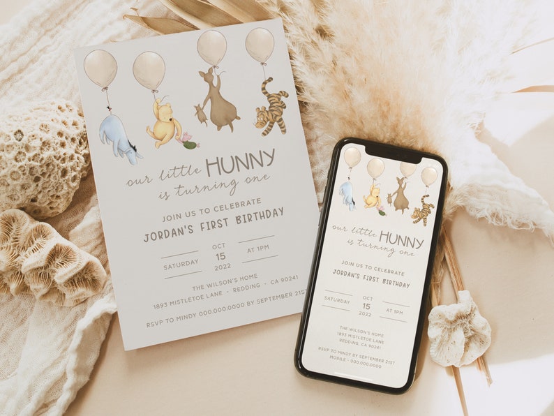May include: A Winnie the Pooh themed first birthday party invitation with a light gray background. The invitation features a cartoon illustration of Winnie the Pooh, Piglet, Tigger, and Eeyore holding balloons. The text on the invitation reads "our little HUNNY is turning one" and "JOIN US TO CELEBRATE JORDAN'S FIRST BIRTHDAY". The invitation also includes the date, time, and location of the party.