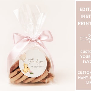 May include: A Winnie the Pooh-themed thank you favor bag with a pink ribbon and a round sticker that says "Thank you for showering us with love". The sticker features a cartoon Winnie the Pooh holding a balloon and a cactus.