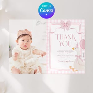 May include: A pink and white thank you card with a photo of a baby wearing a crown. The card features the text "THANK YOU" and a cartoon goose with a party hat and balloon. The card is designed with a pink gingham pattern.