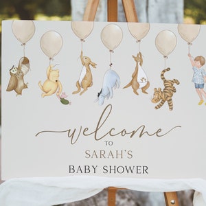 Peut inclure: Une pancarte de bienvenue pour une f&ecirc;te pr&eacute;natale sur le th&egrave;me de Winnie l'ourson avec un fond brun clair. La pancarte pr&eacute;sente une cha&icirc;ne de ballons avec Winnie l'ourson et ses amis qui pendent. Le texte sur la pancarte indique "Bienvenue &agrave; la f&ecirc;te pr&eacute;natale de Sarah".