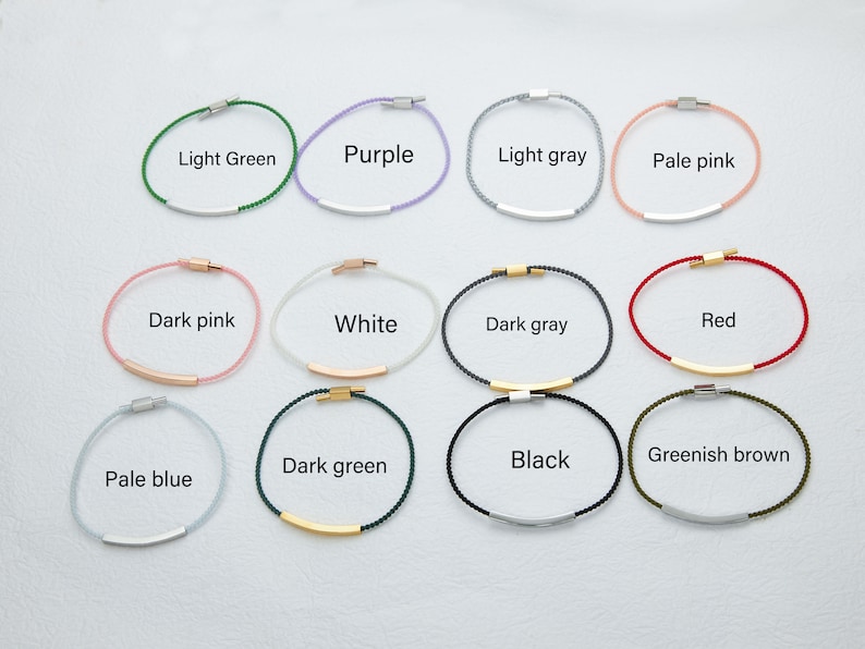 May include: A collection of minimalist bracelets in various colors, including light green, purple, light gray, and pale pink. Each bracelet features a thin cord with a metallic bar and clasp. The text labels each color.