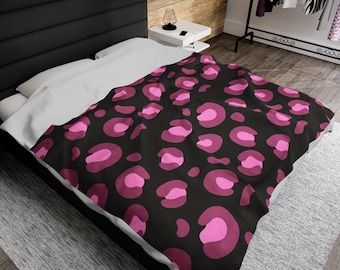 Può includere: Un copripiumino con stampa leopardata nera e rosa con un cuscino bianco su un letto.