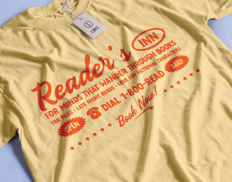 May include: A yellow t-shirt with a red graphic that says "Reader's Inn" and includes the text "For minds that wander through books, TBR piles, late night reads, love for fictional characters, Dial 1-800-READ, Daily, Book Now!"