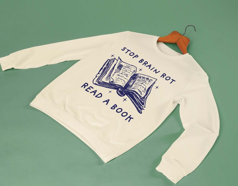 May include: A white sweatshirt with the text "Stop Brain Rot Read A Book" and a blue illustration of an open book.