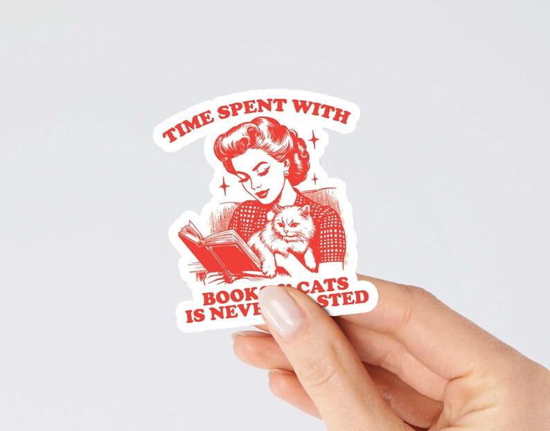 May include: Red and white sticker with a retro illustration of a woman reading a book with a cat in her lap. The text reads "Time spent with books and cats is never wasted."