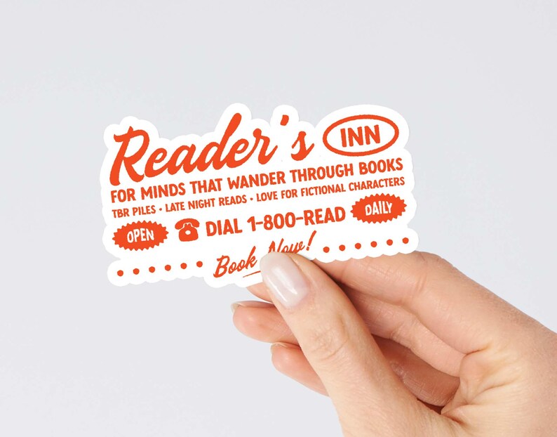 May include: A white sticker with orange text that reads "Reader's Inn" for minds that wander through books. TBR piles, late night reads, love for fictional characters. Open, dial 1-800-READ, daily. Book now!