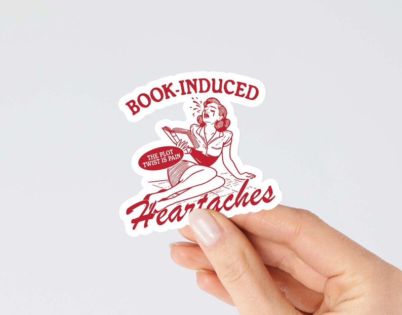 May include: Red and white sticker with a cartoon woman crying and reading a book. The sticker says "Book-Induced Heartaches" and "The plot twist is pain".