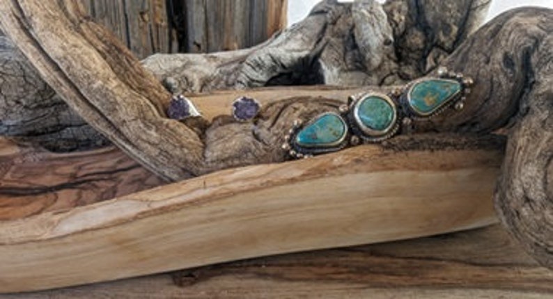 Peut inclure: Une paire de boucles d'oreilles en argent avec des pierres violettes et un bracelet en turquoise et argent avec trois pierres turquoise.