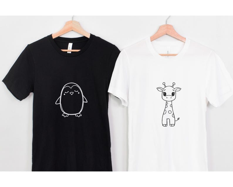 May include: Two t-shirts, one black and one white, each with a simple cartoon animal design. The black shirt features a penguin, and the white shirt has a giraffe. Both designs are in black and white.