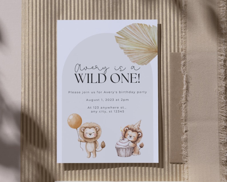 May include: A birthday party invitation with the text "Avery is a WILD ONE!". The invitation features illustrations of a lion holding a balloon and a lion with a cupcake. The invitation is on a white background with a beige arch and a dried palm leaf.