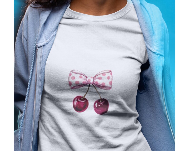 May include: White t-shirt with a pink and white polka dot bow and two pink cherries.