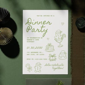 May include: A white invitation card with green text and illustrations for a dinner party. The card includes the text "Dinner Party", date, address, and RSVP information. Decorative paper ornaments and ribbon are on a green surface.