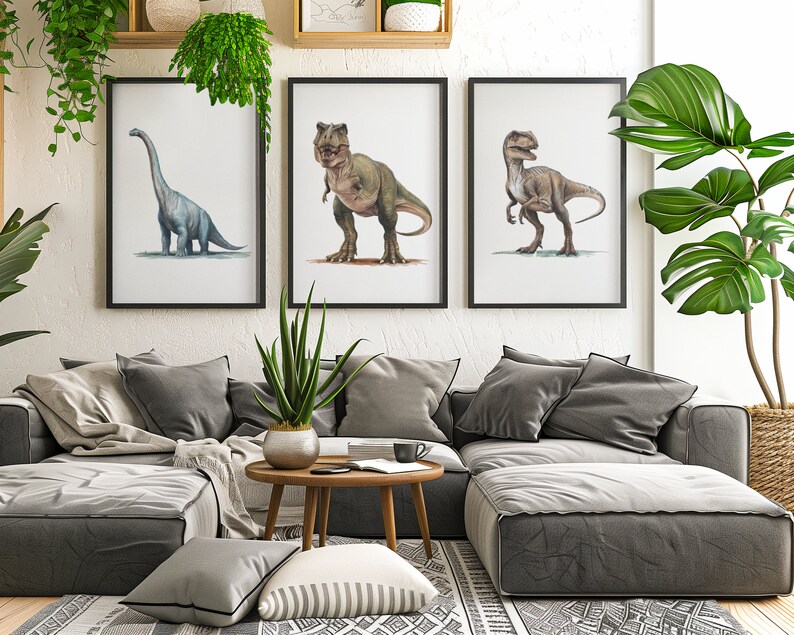 May include: Three framed illustrations of dinosaurs, a blue brachiosaurus, a green Tyrannosaurus Rex, and a brown velociraptor, hanging on a white wall above a gray sectional sofa with pillows and a coffee table.