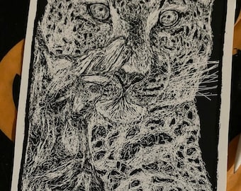 Puede incluir: Un dibujo en blanco y negro de la cara de un leopardo. El dibujo está hecho en un estilo detallado e intrincado, con el pelaje del leopardo representado en una serie de líneas finas.