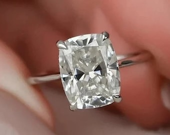 May include: A silver ring with a large, cushion-cut diamond.