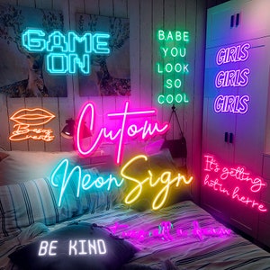 Peut inclure: Une collection de néons avec différentes phrases, dont "Game On", "Babe You Look So Cool", "Girls Girls Girls", "Custom Neon Sign", "Be Kind", et "It's getting hot in here".