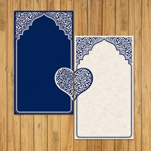 Puede incluir: Dos tarjetas en blanco con intrincados diseños blancos sobre un fondo azul y blanco. Las tarjetas tienen forma de arcos con un corazón recortado en el centro. Las tarjetas están sobre una superficie de madera.