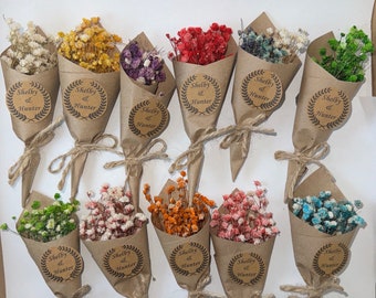 May include: Twelve small bouquets of dried flowers wrapped in brown paper with a twine bow. Each bouquet has a round paper tag with the text "Shelby & Hunter" in a brown font.