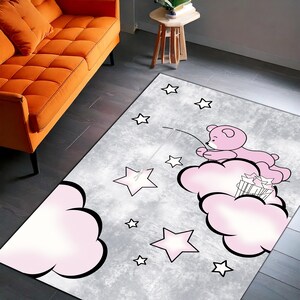 Alfombra con estampado de osito rosa sobre nube: adorable decoración de piso para habitación infantil y de bebé.
