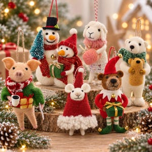May include: A collection of felt Christmas ornaments featuring a pig in a green sweater, a snowman with a tree, a mouse in a red hat, a sheep with a pink scarf, a bear in an elf costume, and a polar bear holding a small bear, all with hanging loops.