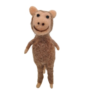 Può includere: Statuetta di scimmia in feltro fatta a mano nei toni del marrone e beige. La scimmia ha un viso sorridente con occhi neri e piccole orecchie. Le braccia e le gambe sono sottili e la coda è corta. La statuetta è in piedi.