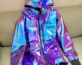 May include: Iridescent hooded jacket in shades of blue, purple, and silver. The jacket features a front zipper, multiple pockets, and a drawstring at the hem. The sleeves have black cuffs. The shiny material gives the jacket a futuristic look.