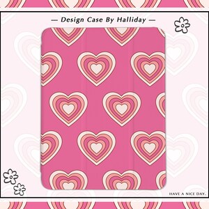 May include: Pink tablet case with a repeating pattern of layered hearts in shades of pink and cream. The case has the text "DESIGN CASE BY HALLIDAY" and "HAVE A NICE DAY."