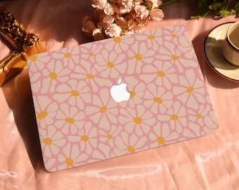 May include: A pink laptop skin with a white daisy pattern and yellow centres. The skin has the Apple logo cut out.