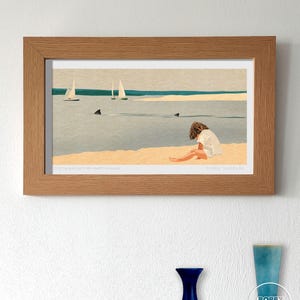 Op de afbeelding: Een ingelijste kunstdruk met een strandscène met zeilboten, haaien en een persoon op het zand. Het kunstwerk heeft een minimalistische stijl met blauwe, beige en bruine tinten. De tekst onderaan luidt "DO YOU KNOW THE MUFFIN MAN?" en "BOBBY DAZZLER".