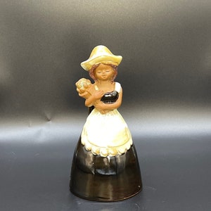 Rare Ceramic table bell in a shape of a smiling girl with a bouquet.
