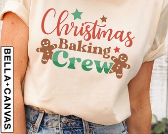 May include: A beige t-shirt with the text "Christmas Baking Crew" in red, green, and brown. The text is surrounded by gingerbread men and stars.