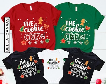 May include: A set of four Christmas shirts featuring a gingerbread man and the text "The cookie crew". The shirts are in red, green, black, and white.