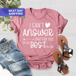 May include: A pink t-shirt with the text "I can't answer that for you, do the best you can" in white lettering with a heart symbol.