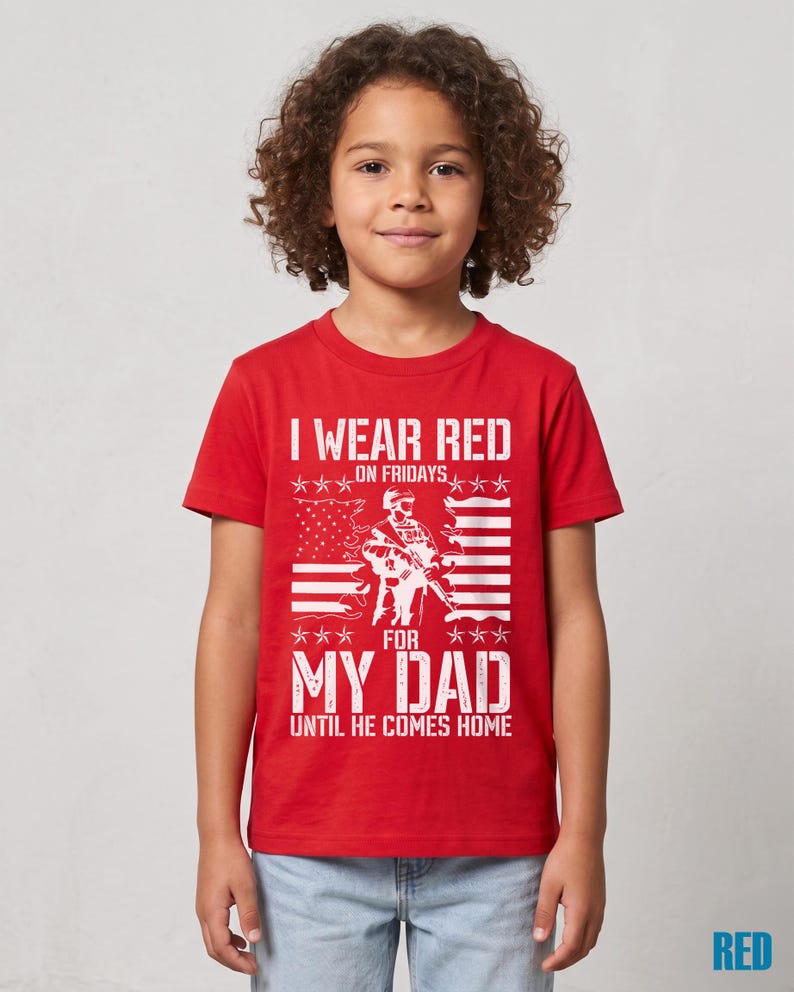 May include: A red short-sleeved t-shirt featuring a white graphic print of a soldier silhouette, a stylized American flag, and the text: I WEAR RED ON FRIDAYS FOR MY DAD UNTIL HE COMES HOME. The design includes star accents above and below the soldier.