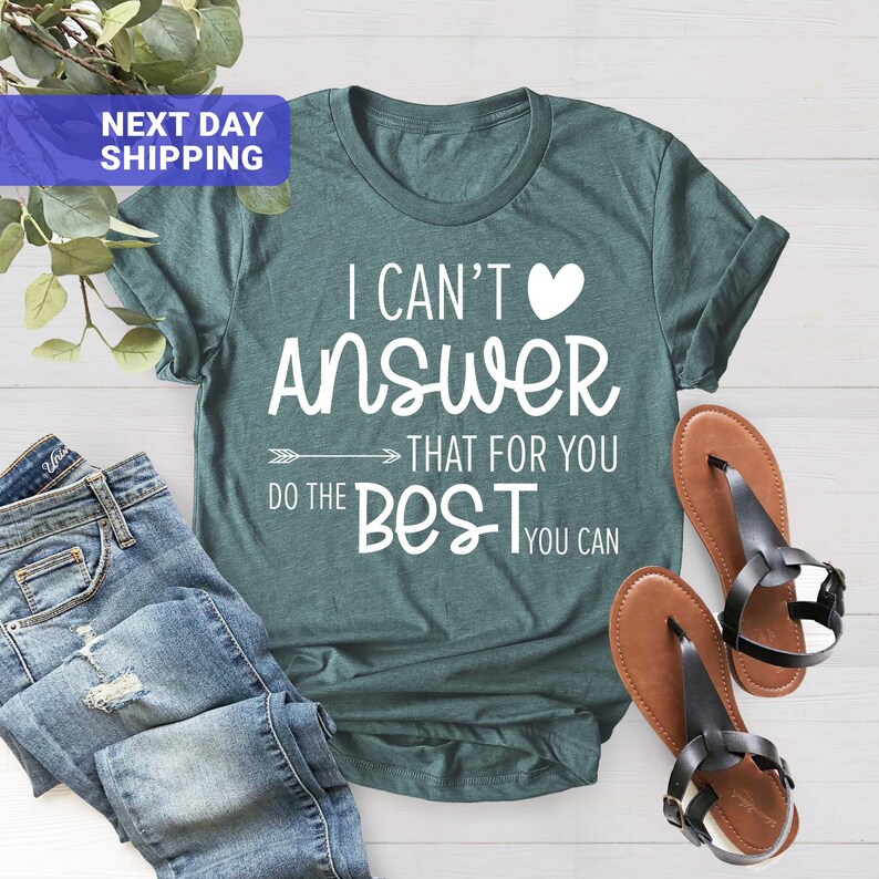 May include: Teal blue t-shirt with white text that reads "I can't answer that for you, do the best you can" with a white heart symbol.