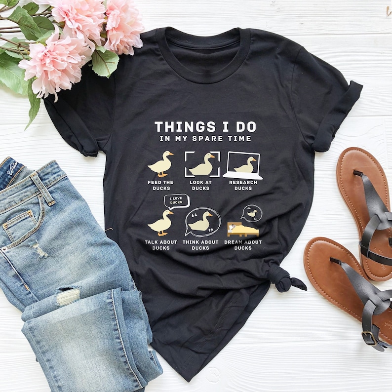 May include: Black t-shirt with a white graphic of ducks and the text "Things I do in my spare time". The graphic shows ducks being fed, looked at, researched, talked about, thought about, and dreamed about.