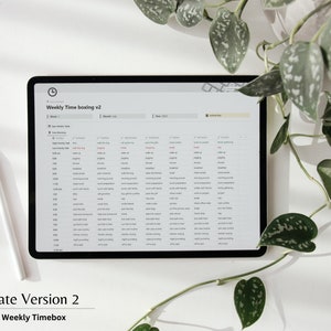K&ouml;nnte beinhalten: Ein wei&szlig;es Tablet mit einem schwarzen Bildschirm, auf dem eine w&ouml;chentliche Timeboxing-Vorlage in der Notion-App angezeigt wird. Die Vorlage tr&auml;gt den Titel "Weekly Timeboxing v2" und enth&auml;lt ein Raster mit st&uuml;ndlichen Zeitfenstern von 6:00 Uhr morgens bis 23:00 Uhr abends. Der Bildschirm zeigt auch eine Liste von Aufgaben f&uuml;r jede Stunde an, wie z. B. "Aufstehen", "Fr&uuml;hst&uuml;ck", "Arbeit" und "Abendessen".