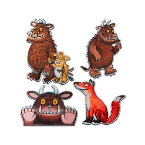 May include: Four embroidered patches featuring characters from a children's book. The patches include a brown monster, a yellow creature, a red fox, and a brown monster with large teeth and hands.