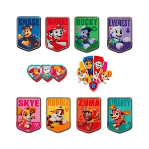 May include: A collection of colorful Paw Patrol patches featuring various characters like Chase, Marshall, and Skye. Each patch has a unique design with the character's name. The patches are in various shapes and sizes, with vibrant colors.