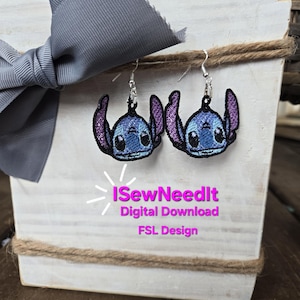 May include: A pair of Stitch earrings with silver hooks. The earrings feature a blue and purple embroidered design of the character Stitch. The earrings are displayed on a white wooden box with a grey bow and the text "I Sew Need It Digital Download FSL Design."