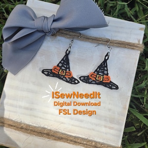 May include: A pair of black witch hat earrings with orange buckles, displayed on a white wooden surface with a gray bow. The earrings are part of a digital download FSL design. The text "I Sew Need It" is also visible.