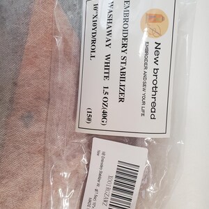 May include: A package containing white washaway embroidery stabilizer. The label reads "New brothread EMBROIDERY STABILIZER WASHAWAY WHITE 1.5 OZ (40G) 25.4cm x 9.14m/ROLL". The package also includes a barcode and the text "MADE IN CHINA".